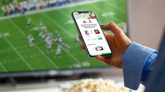 A person uses the FanUp app while watching the game.