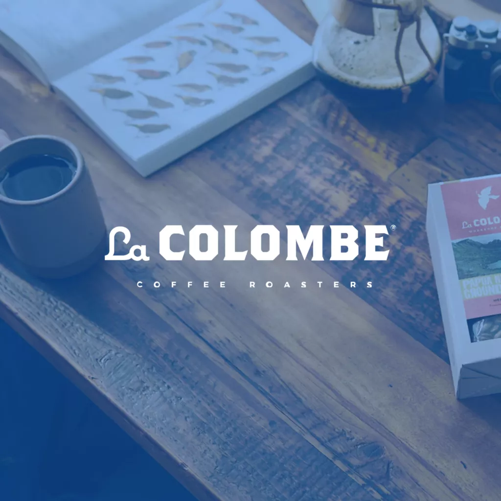 La Colombe logo on blue overlay photo of coffee table.