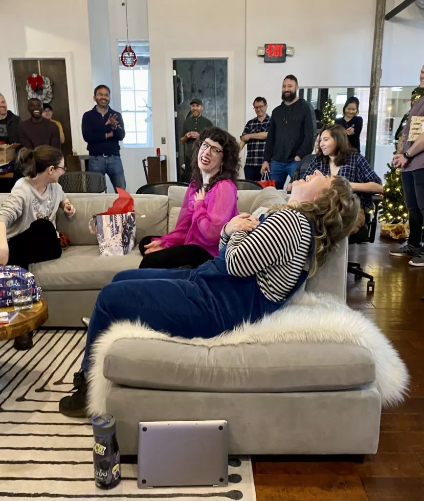 Two team members laughing during gift exchange.