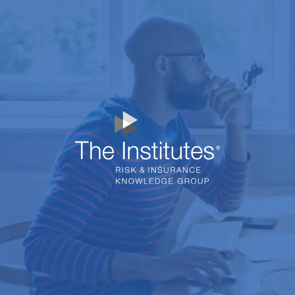 The Institutes logo in front of blue overlay photo of man working at computer.