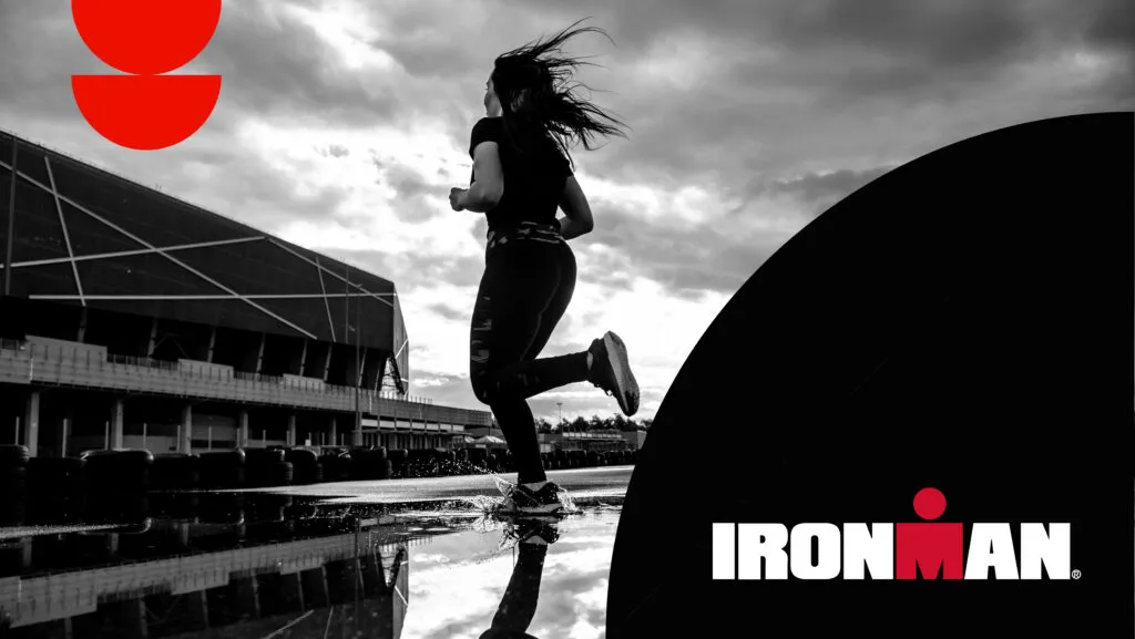 IRONMAN race photo of a woman running across a puddle