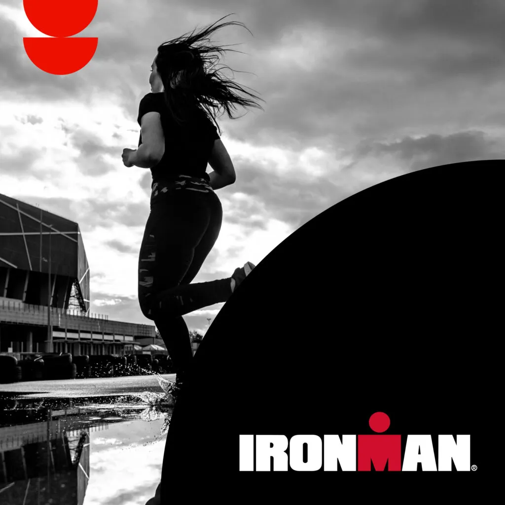 IRONMAN race photo of a woman running across a puddle