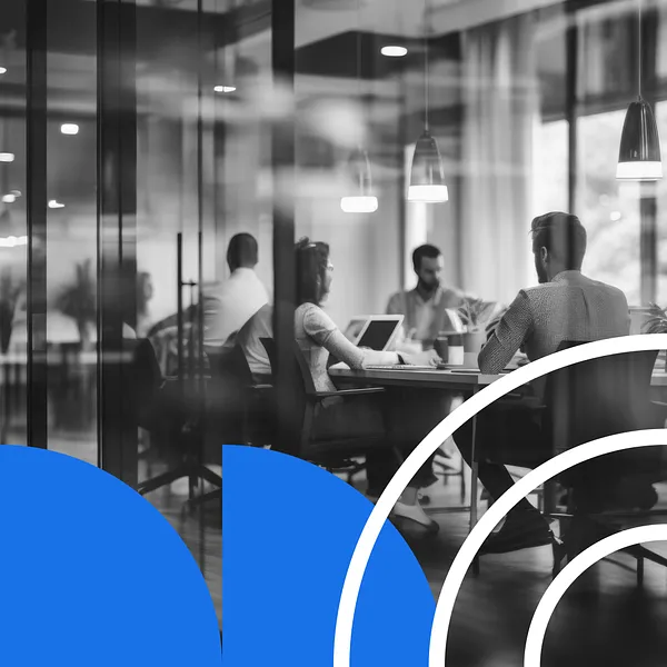 Individuals sitting at a conference table discussing the benefits of an AI-connected CMS